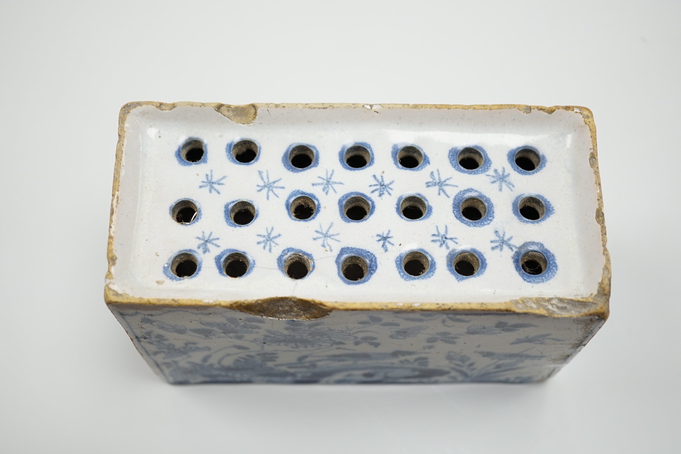 A mid 18th century English delftware flower brick, probably Lambeth, painted in underglaze blue with a stylised pheasant and foliage, 15cm wide